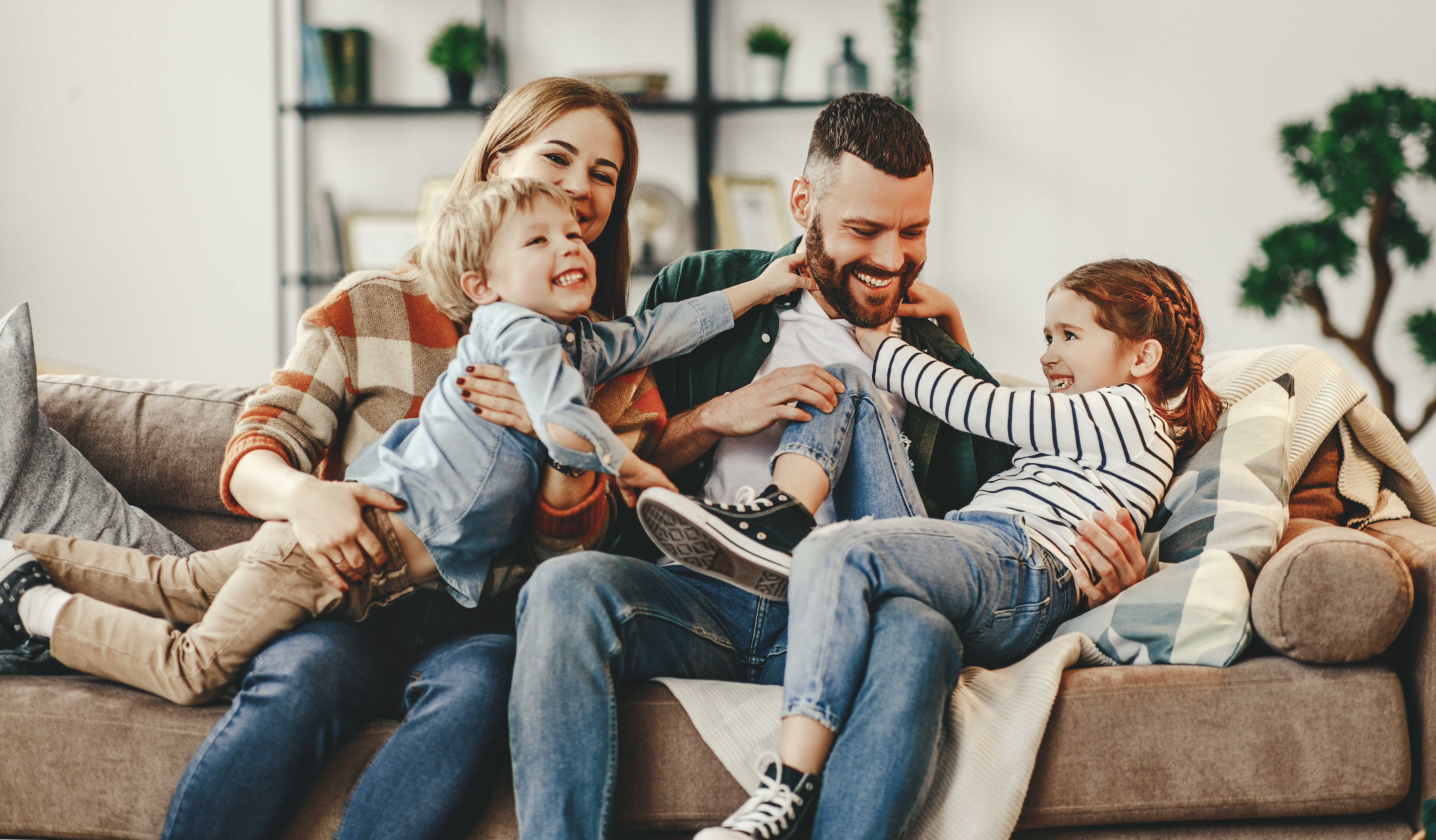 family on sofa in newly eligible home